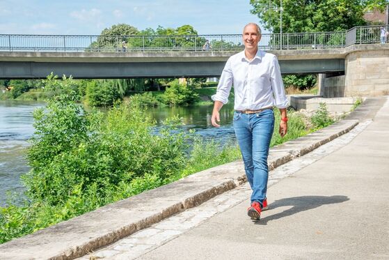 MdB Christoph Schmid läuft am Wasser entlang